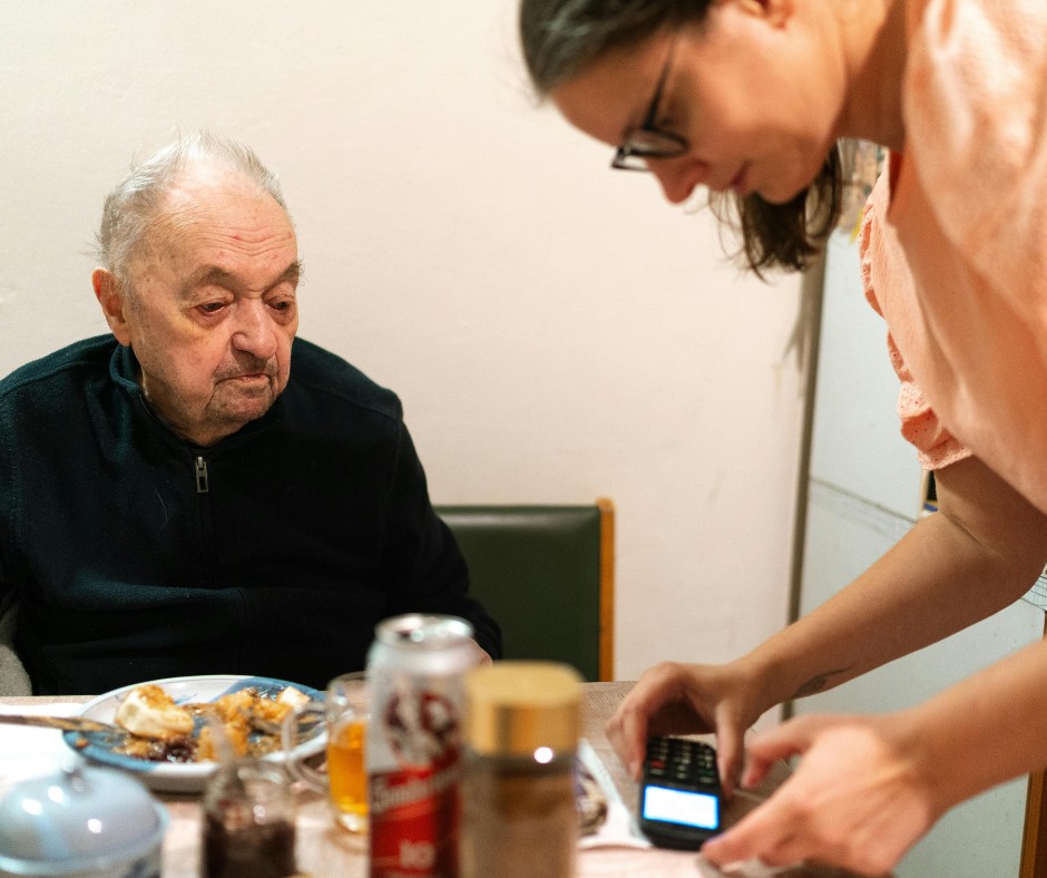 woman assisting an elderly to eat